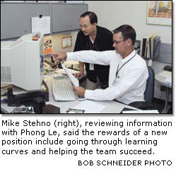 Mike Stehno (right), reviewing information with Phong Le