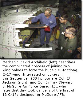 Mechanic David Archibald (left) describes the complicated process of joining two wing halves